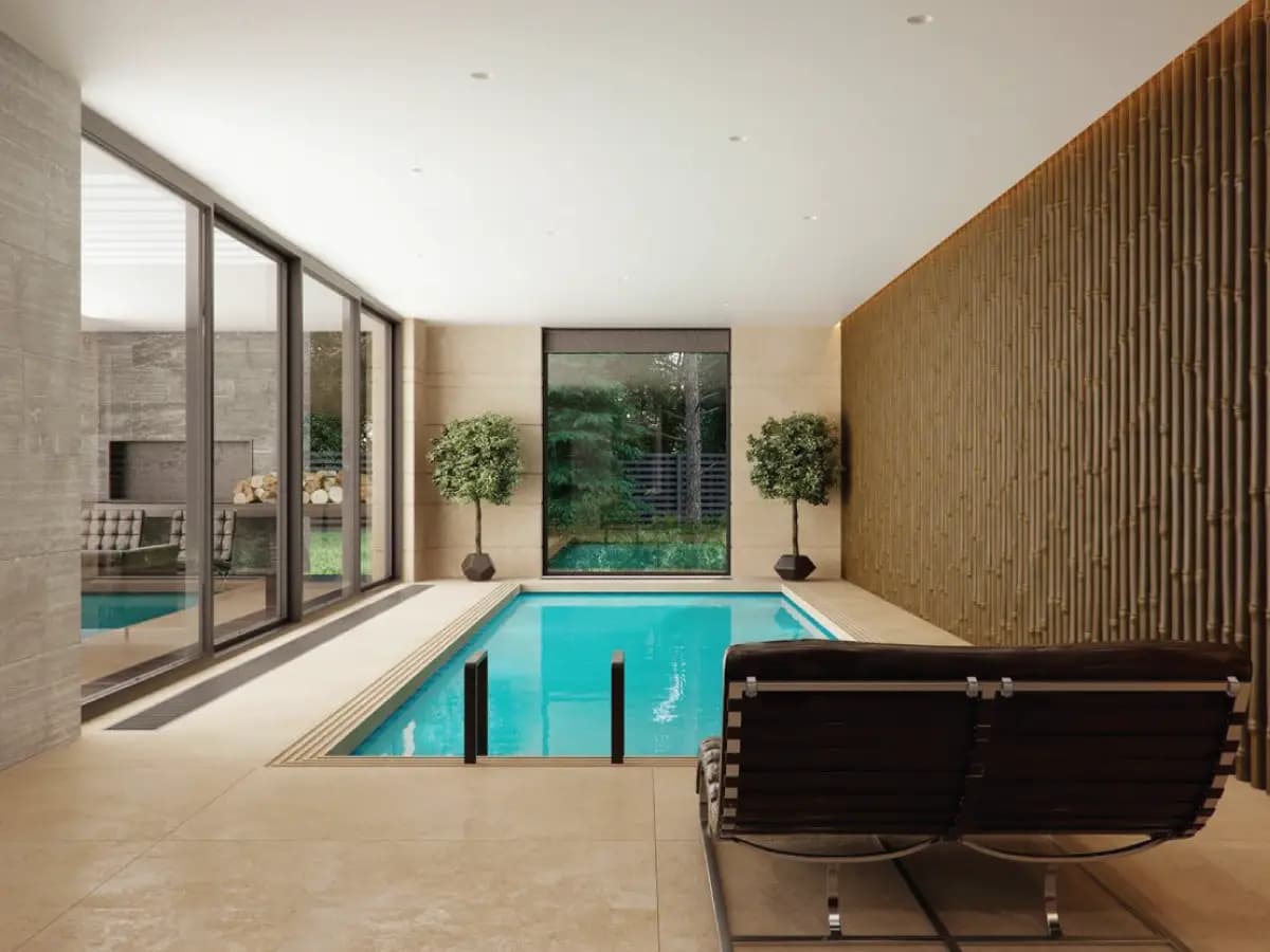   Indoor concrete jacuzzi with tiled finishes and entry handrail